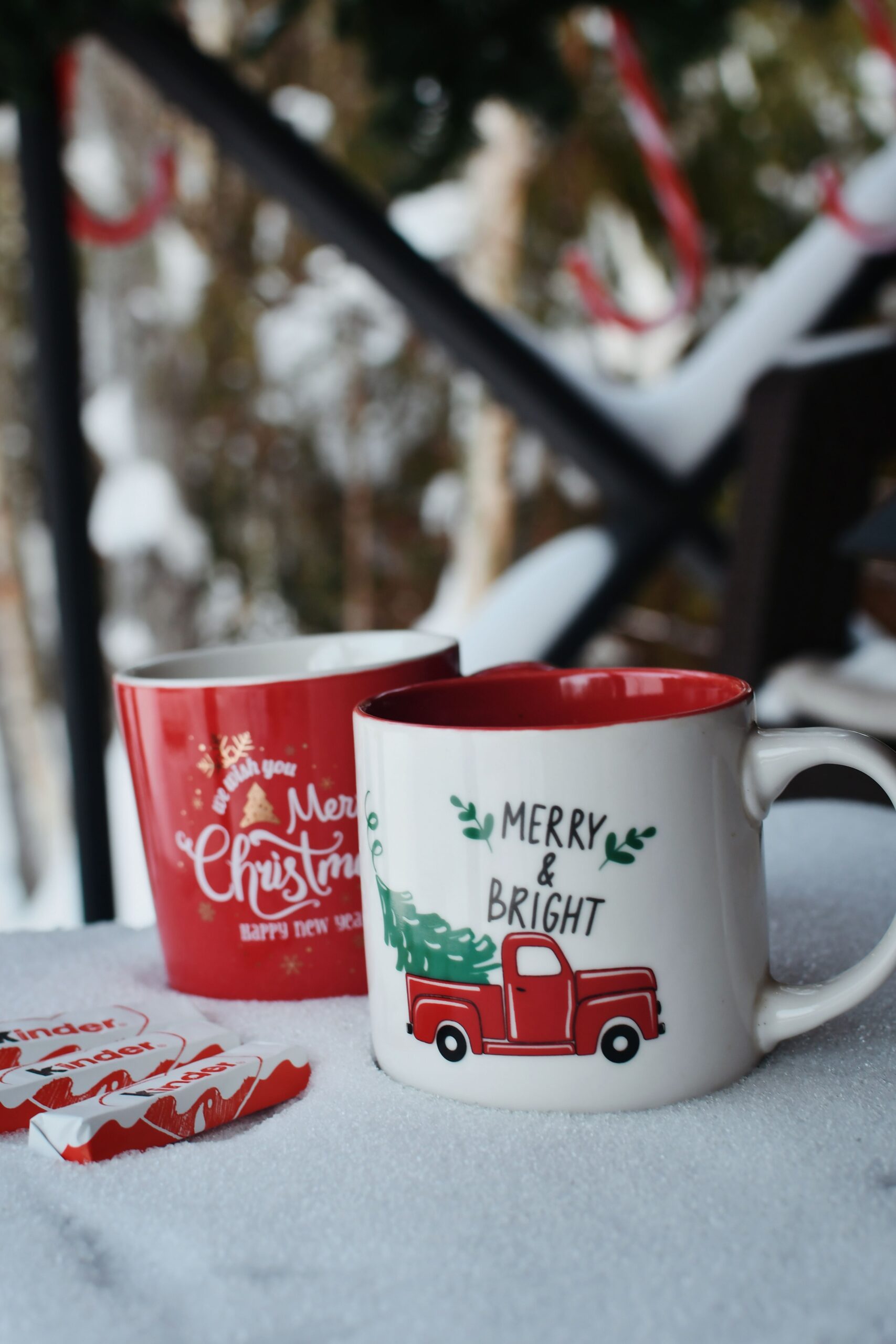 Two festive mugs on snow with a Merry Christmas theme, perfect for winter holiday vibes.